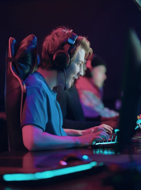 Gamer mit Headphones vor Bildschirm