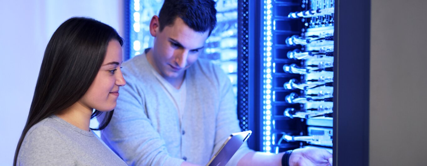 Zwei Mitarbeiter arbeiten am Server Rack